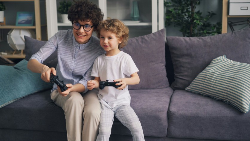 Mom and child playing video games on a couch