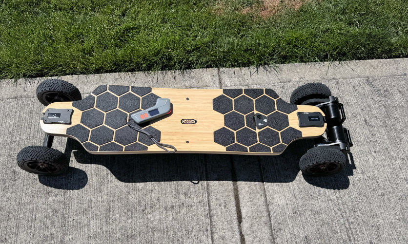 Meepo Rover e-skateboard on pavement with grip pads and remote