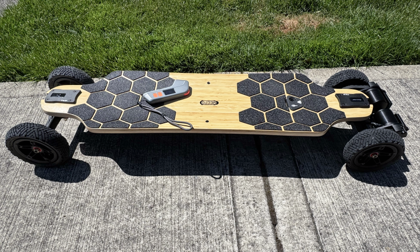 Meepo Rover electric skateboard on sidewalk with remote and grip