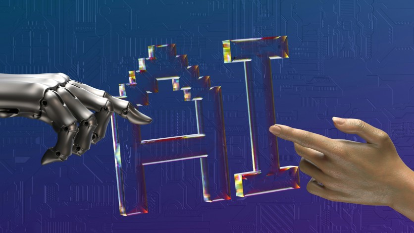 Robot hand, human hand, and “AI” text