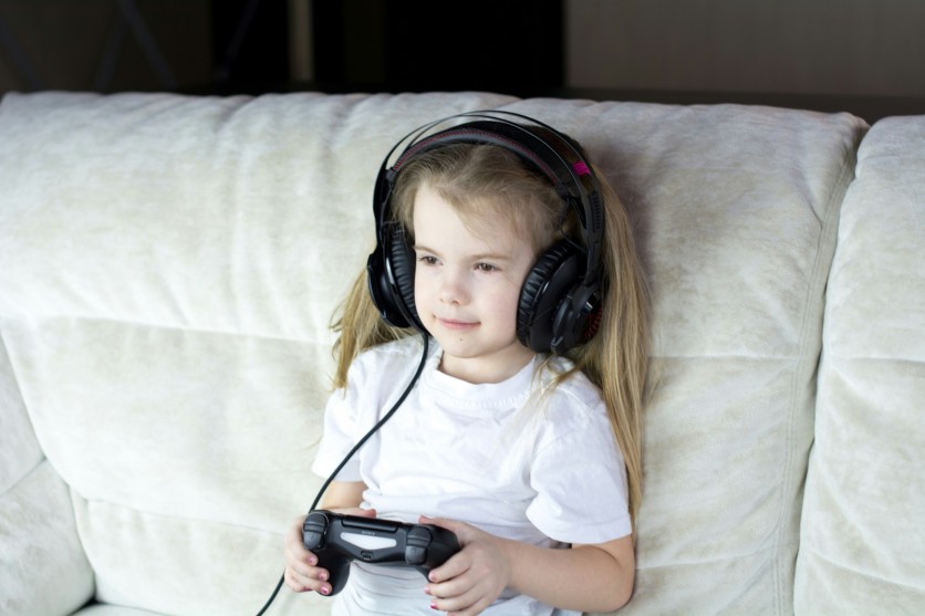 Young child gaming with headset and controller