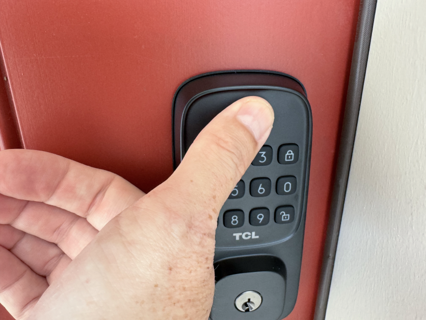 Person using fingerprint scanner on TCL smart lock