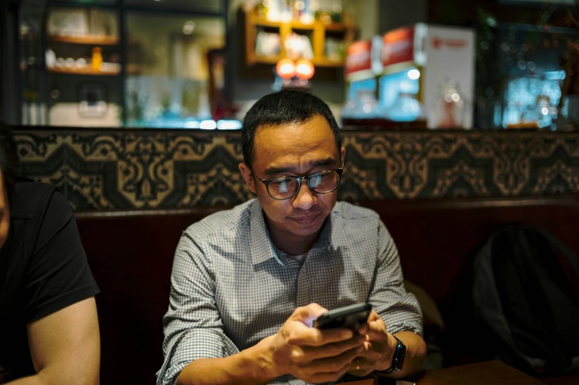 Man texting on his phone in a café