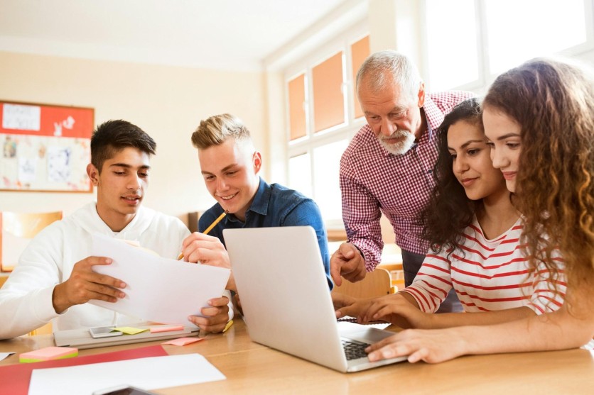 High school students collaborating with teacher guidance while using edYOU