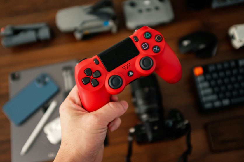 Person Holding a Red PS4 Controller
