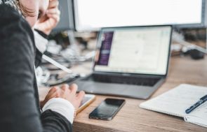 Person With Smartphone and Laptop at Workplace