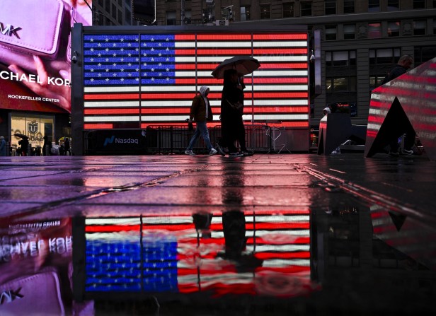 People walk past an American Flag display at Time Square