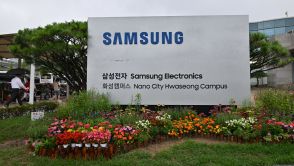 People walk past a signboard of Samsung Electronics outside the