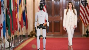 US First Lady Melania Trump walks with a humanoid robot