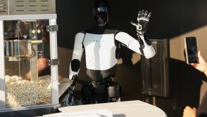 A Tesla Optimus robot scoops popcorn and waves at attendees