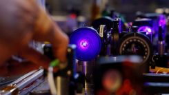 A student checks lasers for an experimentation during a visit