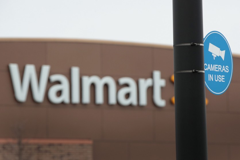 A sign warns customers that cameras are monitoring the parking