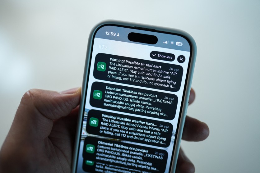 This photograph shows a person holding a mobile phone that