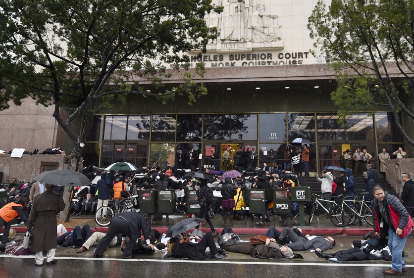 Lawyers, law students and legal staff lie on the ground