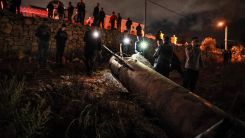 Palestinian youths inspect a fallen projectile after Iran launched a