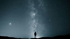 Silhouette of a Person Under the Starry Night Sky