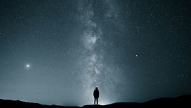 Silhouette of a Person Under the Starry Night Sky