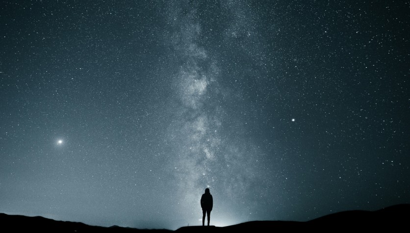 Silhouette of a Person Under the Starry Night Sky
