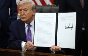U.S. President Donald Trump displays a signed executive order in