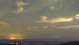 A Perseid meteor streaks across the sky over the community