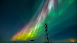 A dazzling display of multicolored auroras stretches diagonally across the