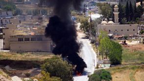 Smoke rises from a vehicle targeted by an drone attack