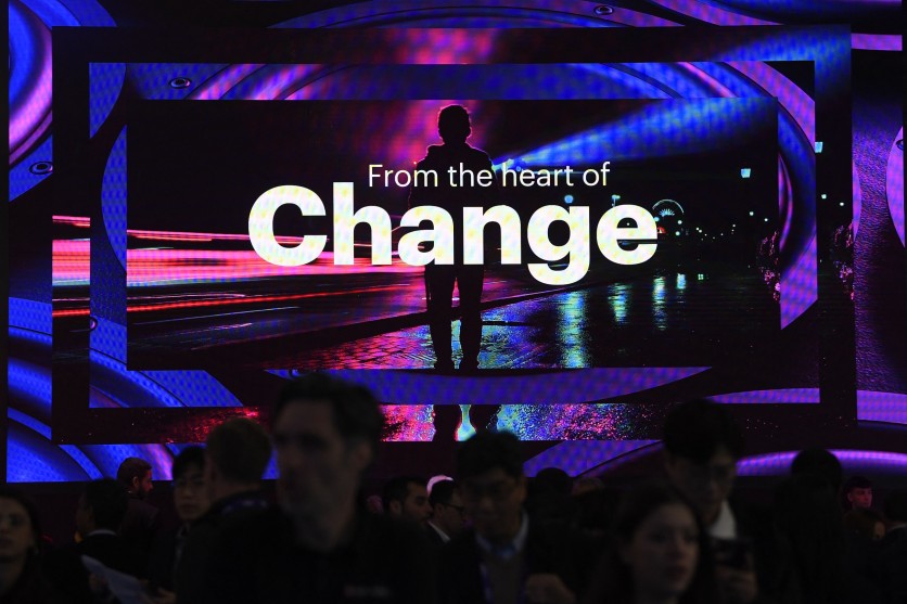 Visitors walk past a screen of Irish-American company Accenture, at