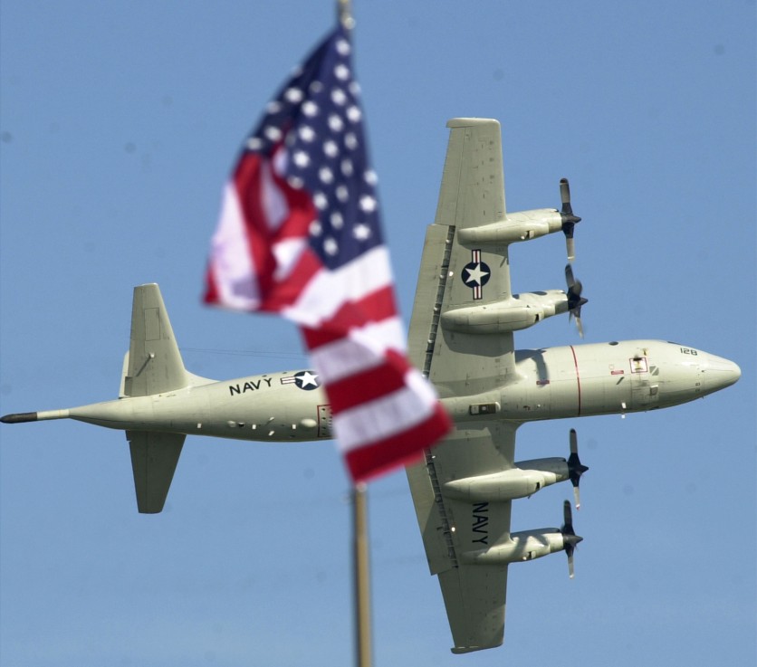 Navy P-3 Orion is framed by a flag as it